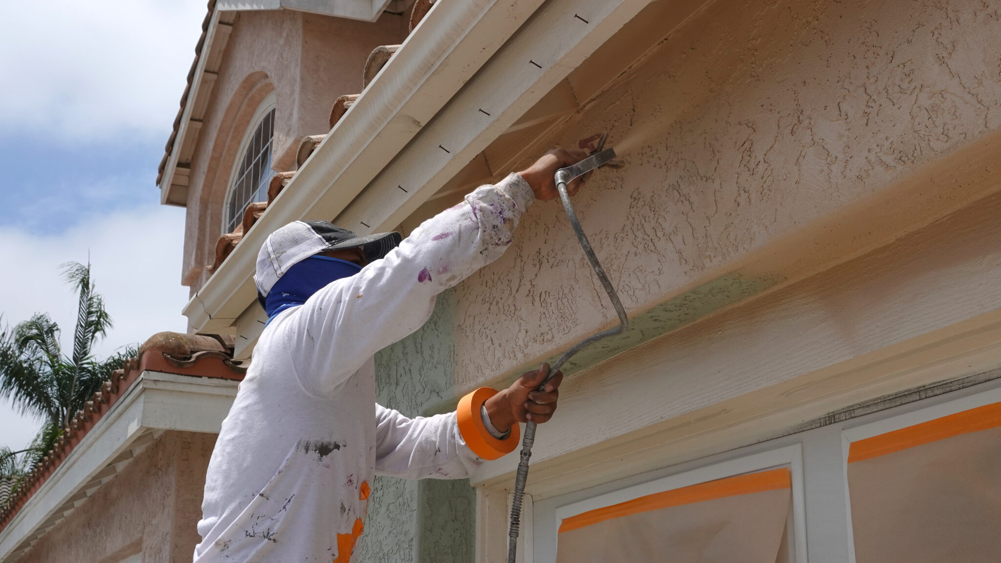 Professional contractor using a spray paint gun to paint the stu